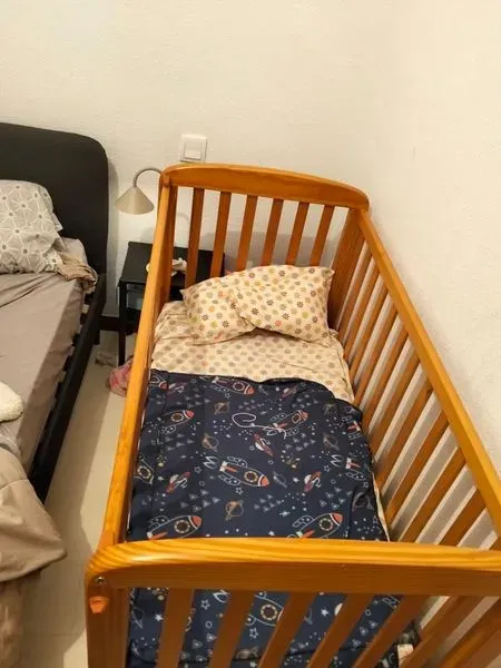Cuna de madera con ropa